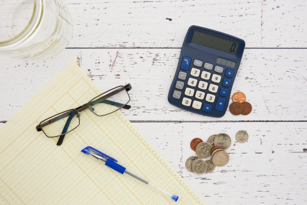 A calculator and finance plans on a desk — weighing up the three Creditcorp products